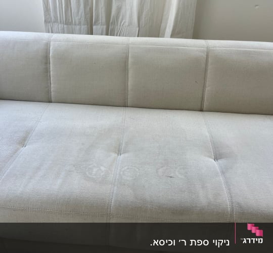 ספה בהירה עם כתמים על המושב